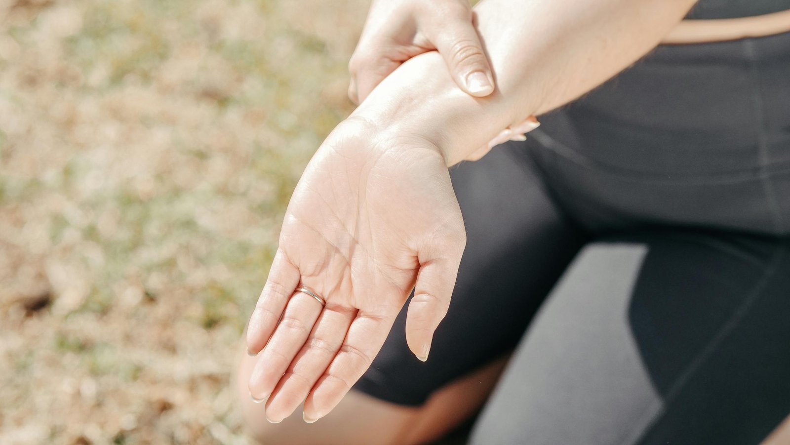 Woman holding her stiff hand in morning light – early RA signs”