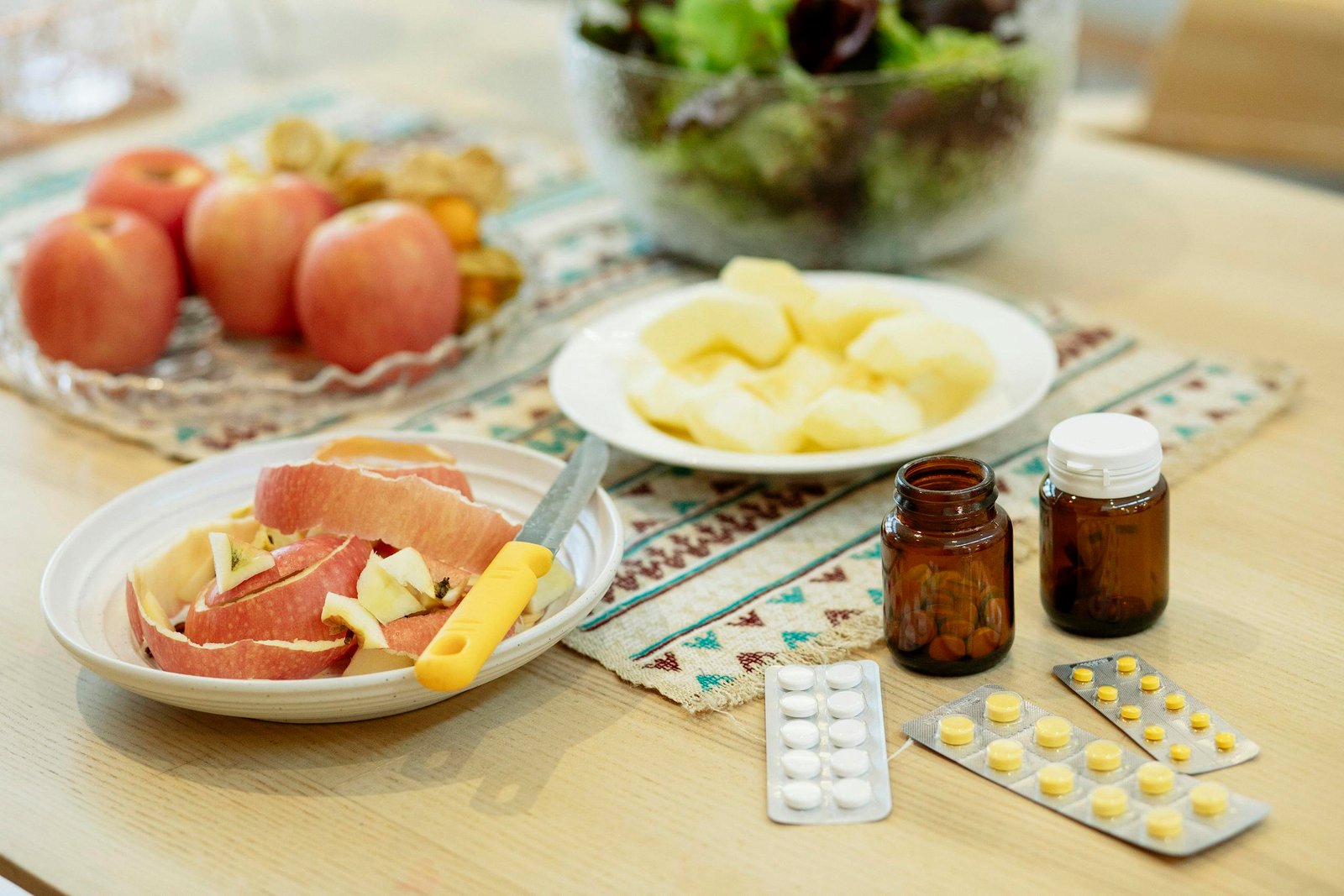 A wholesome scene showcasing apples, salad, and various supplements for a balanced diet.